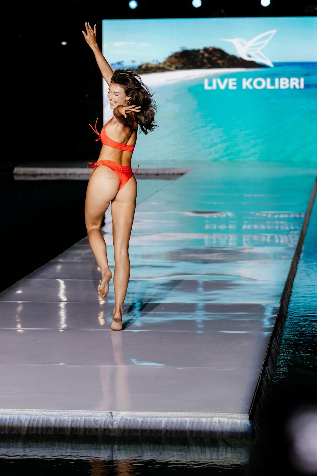 Model wearing cherry red lace-up bikini set with halter neck top and side-tie bottoms