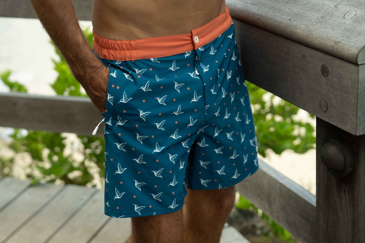 Model wearing Deep Ocean monogram swim trunks outdoors