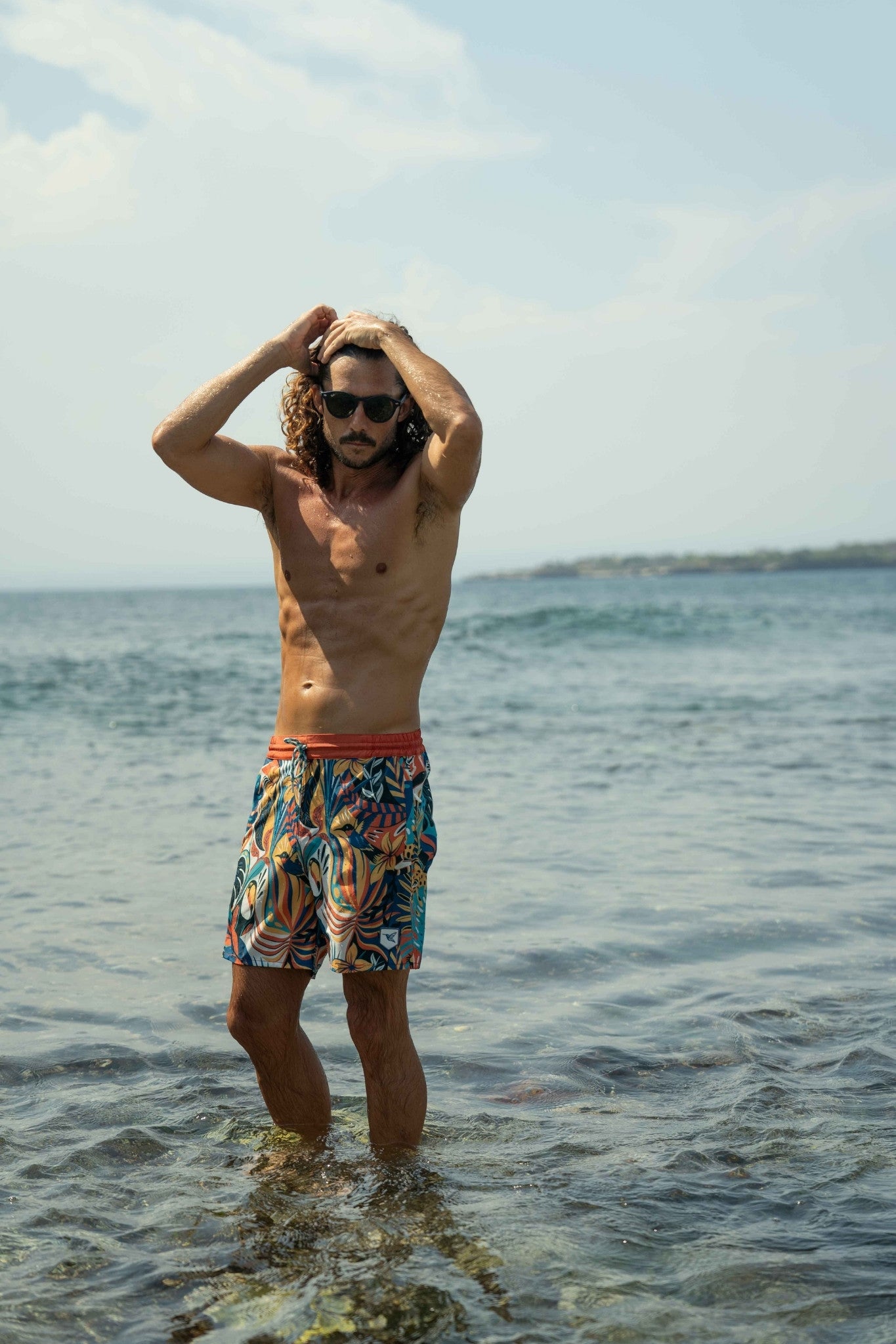 Model wearing eco-friendly jungle print swim shorts outdoors