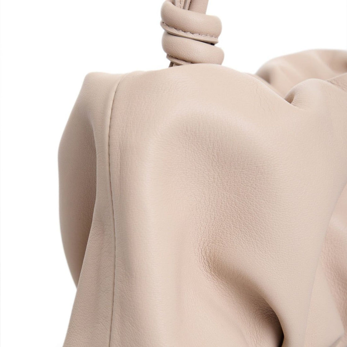 Close-up of a beige handbag with a knot detail on a white background