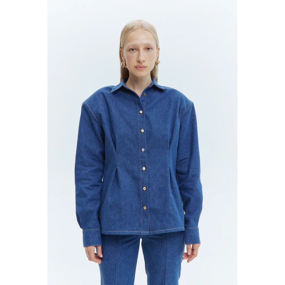 Person wearing a blue shirt and pants on a white background