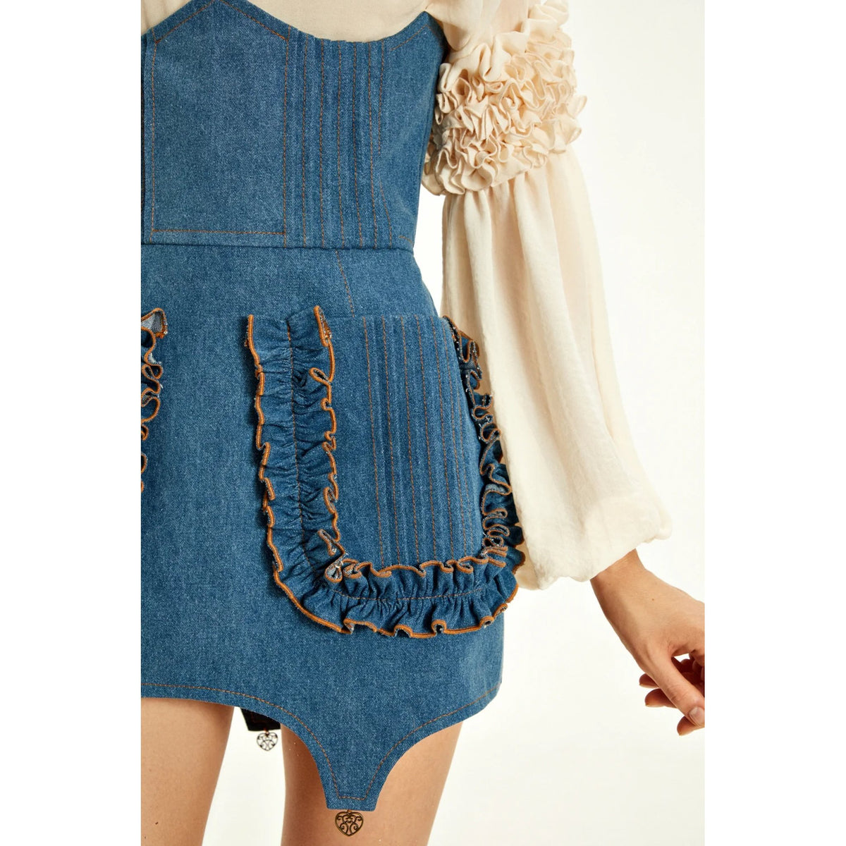 Blue denim corset skirt with ruffled details on a white background