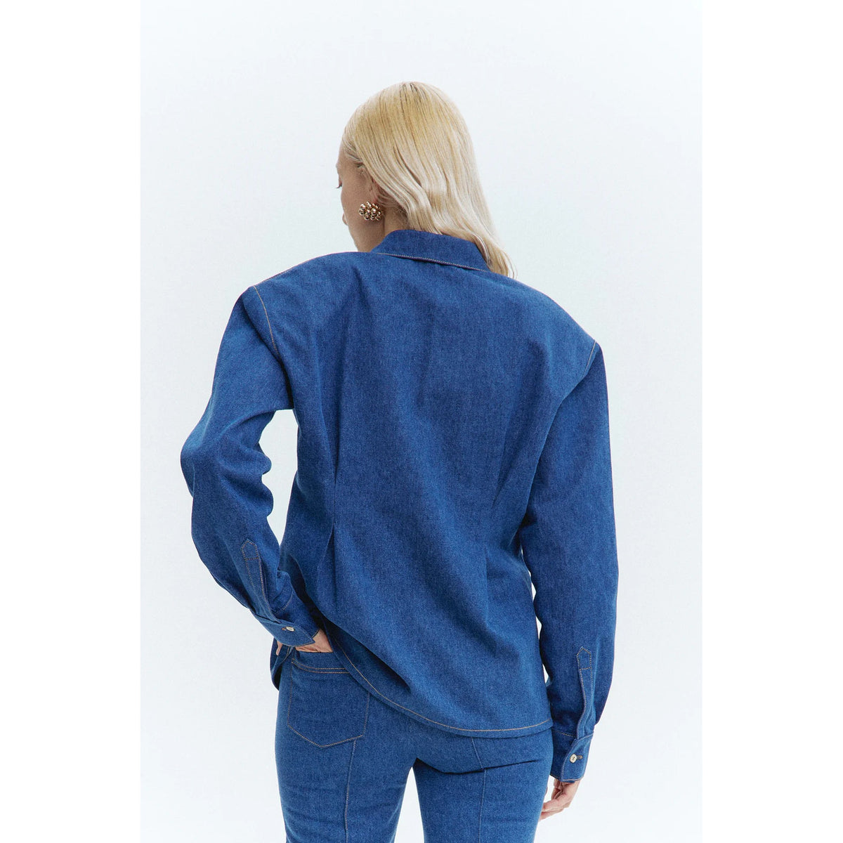 Person wearing a blue denim outfit on a white background