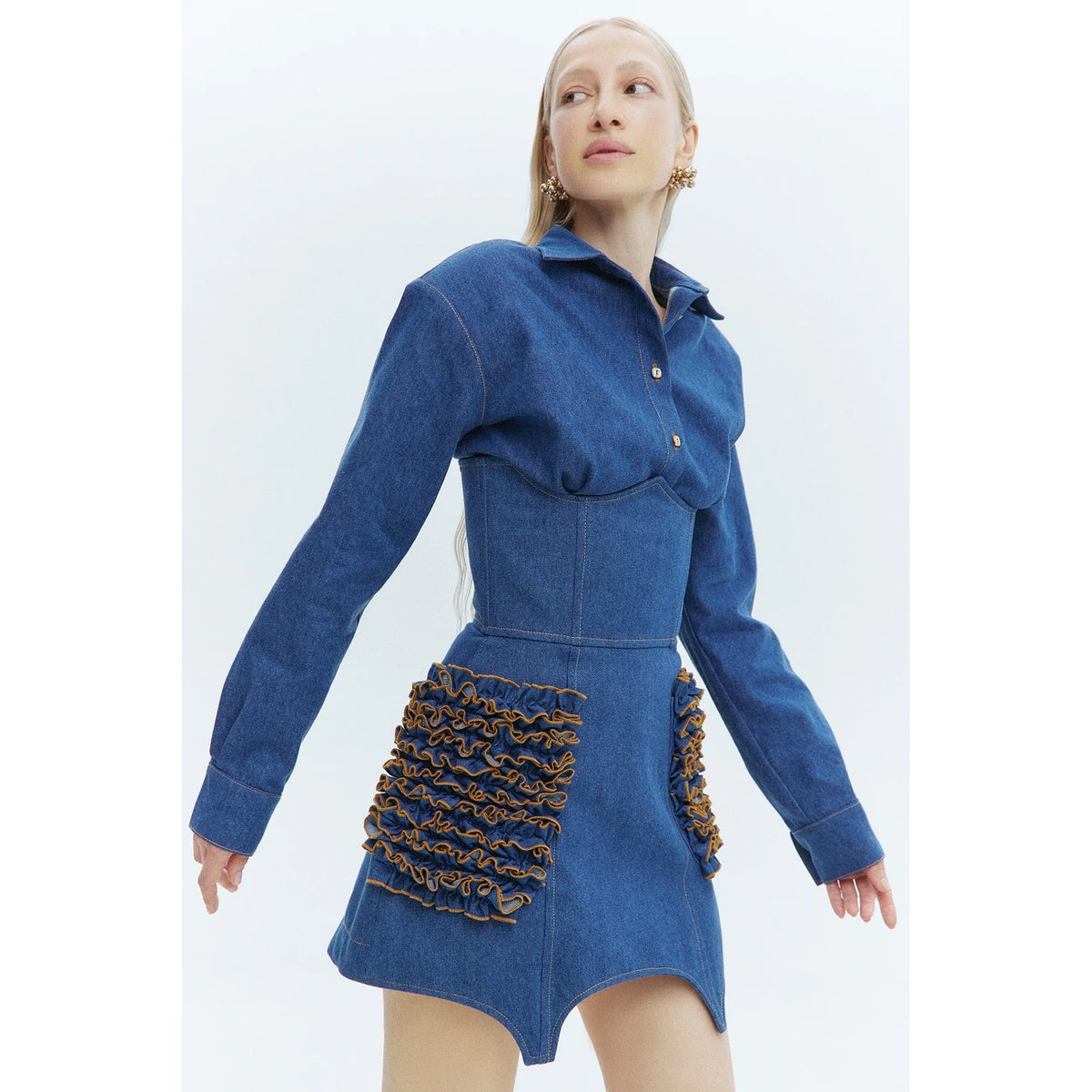 Woman wearing a blue dress with a textured skirt on a white background