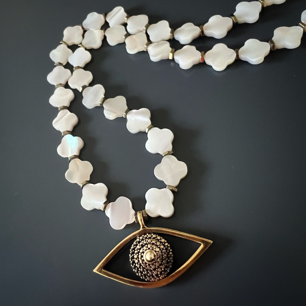 Stylish Pearl Clover Necklace with gold color hematite spacers and symbolic Evil Eye charm.