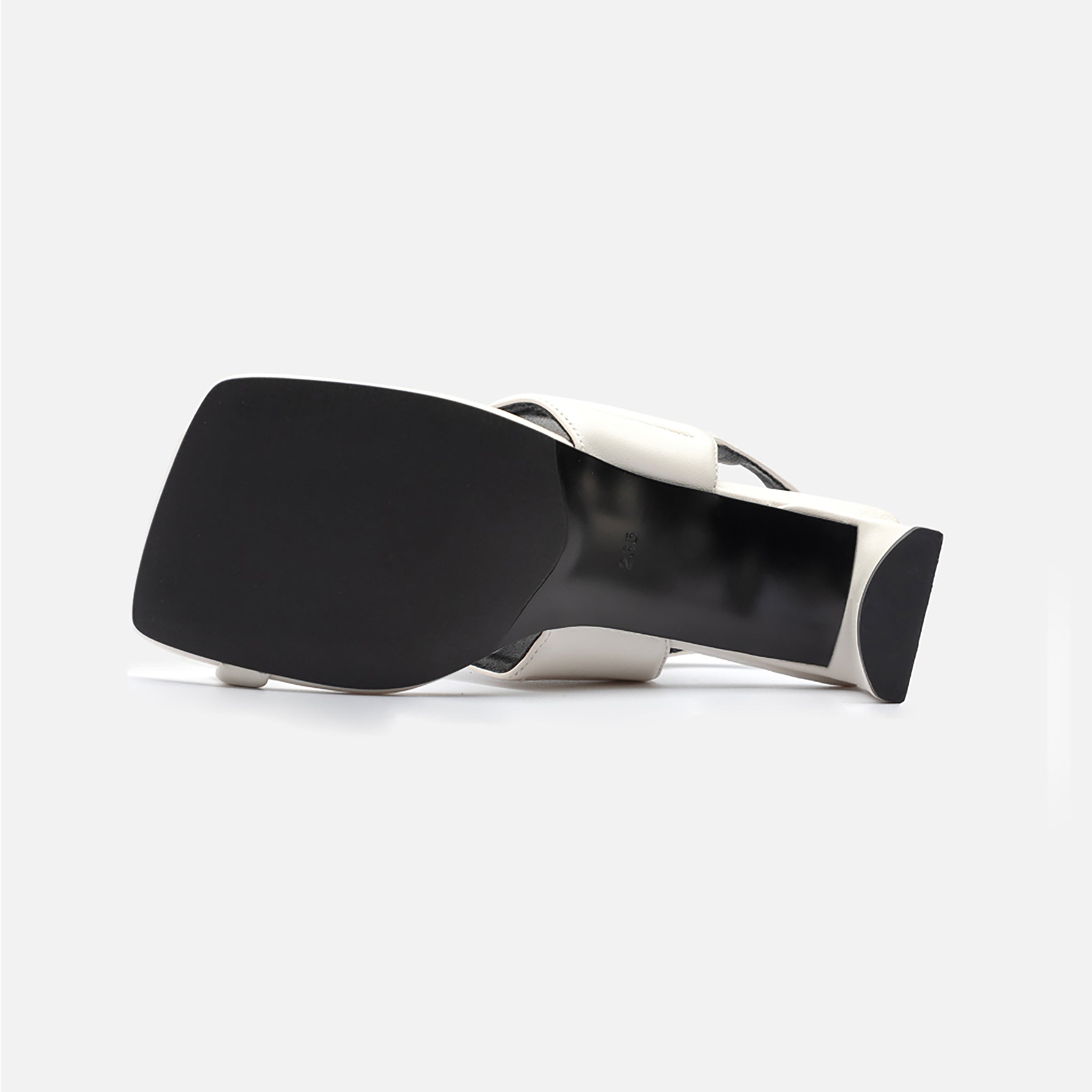 The THEN White Square-Toe Slingback Heeled Sandals rest on their side, highlighting a large flat black sole against a plain light gray background—an elegant display of minimalist footwear.